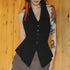 Person wearing a black vest against a wooden background